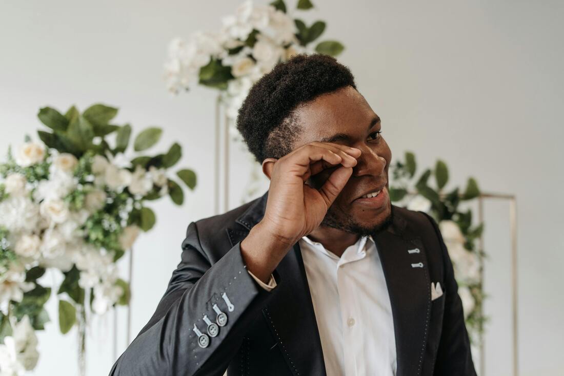 Man wiping his tear on his wedding day